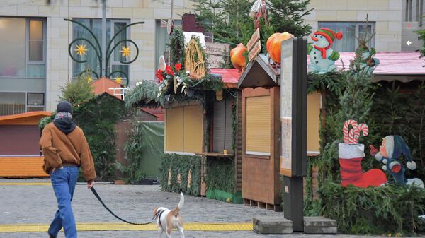 Мужчина идет по закрытой рождественской ярмарке в Дрездене - Sputnik Беларусь