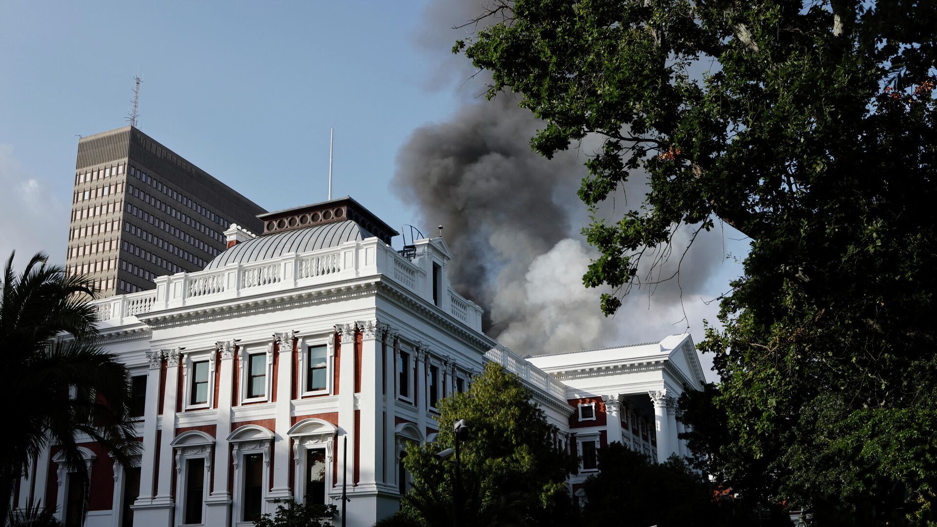 Дымовые клубы поднимаются с крыши здания у здания парламента Южной Африки в Кейптауне 2 января 2022 года во время пожара - Sputnik Беларусь, 1920, 02.01.2022
