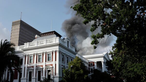 Дымовые клубы поднимаются с крыши здания у здания парламента Южной Африки в Кейптауне 2 января 2022 года во время пожара - Sputnik Беларусь