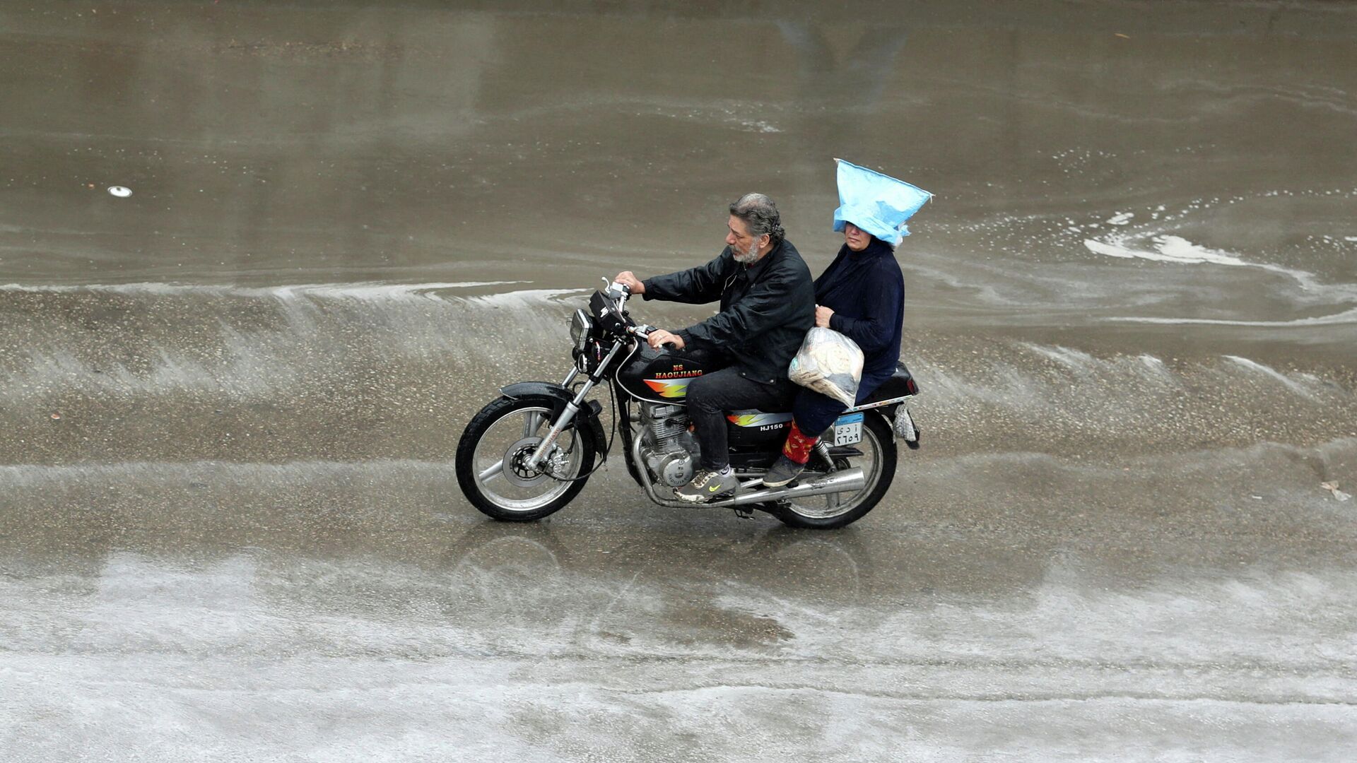 Люди катаются на мотоциклах во время грозы и сильного дождя в Каире - Sputnik Беларусь, 1920, 02.01.2022