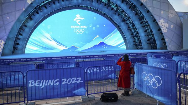 Женщина фотографирует место вручения медалей зимних Олимпийских игр 2022 года в Пекине - Sputnik Беларусь