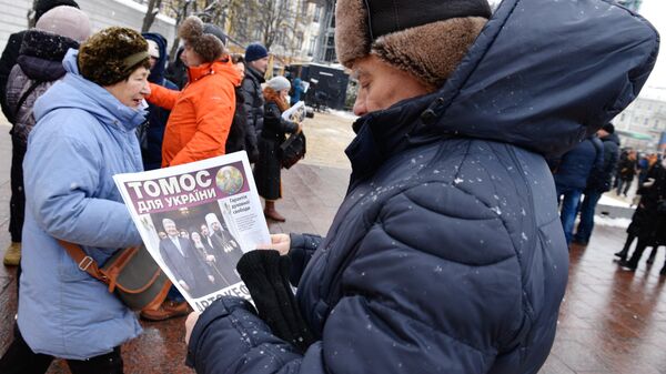Мужчына чытае газету на Сафіеўскай плошчы ў Кіеве, архіўнае фота - Sputnik Беларусь