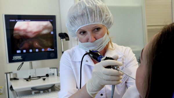 Врач-отоларинголог во время работы с пациенткой - Sputnik Беларусь