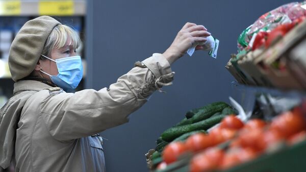 Женщина в защитной маске покупает продукты в магазине - Sputnik Беларусь