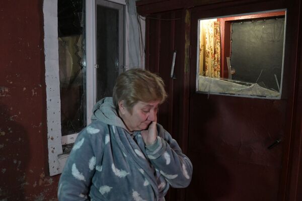 Женщина во дворе своего дома, пострадавшего в результате обстрела, в поселке шахты &quot;Трудовская&quot; в Донецке. - Sputnik Беларусь