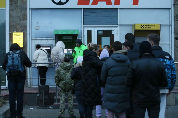 Граждане стоят в очереди для того чтобы снять денежные средства в банкомате на одной из улиц в Киеве. - Sputnik Беларусь