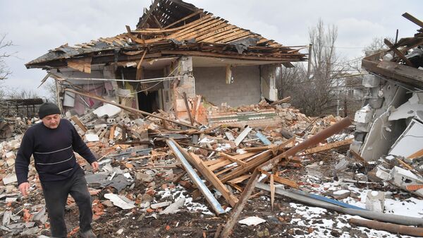 Житель села Сопино в Донецкой народной республике у одного из разрушенных домов - Sputnik Беларусь