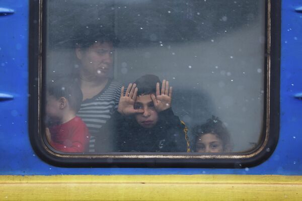 Дети смотрят из окна поезда на перроне во Львове.  - Sputnik Беларусь