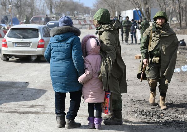 Военнослужащий НА ДНР общается с беженцами на выезде из Мариуполя - Sputnik Беларусь
