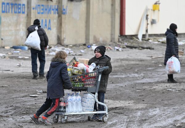 Дети с продуктовой тележкой возле магазина Metro в Мариуполе - Sputnik Беларусь