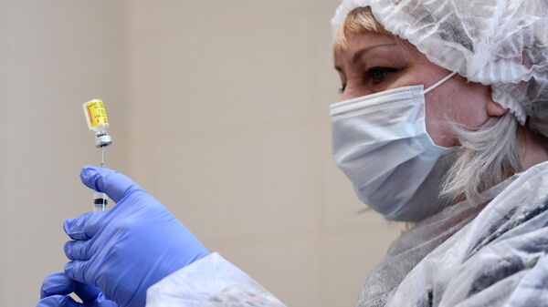 Медицинский сотрудник наполняет шприц вакциной от коронавируса - Sputnik Беларусь