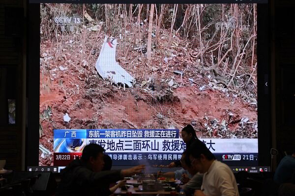 На экране показаны кадры с места крушения самолета Boeing 737-800 China Eastern Airlines, летевшего из Куньмина в Гуанчжоу. - Sputnik Беларусь