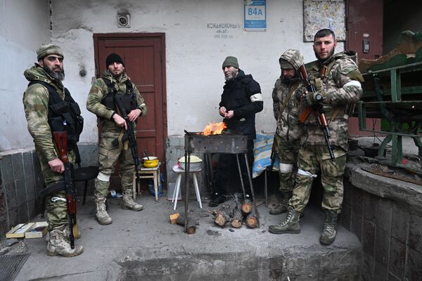 Бойцы специального отряда быстрого реагирования Ахмат готовят еду на улице в Мариуполе - Sputnik Беларусь