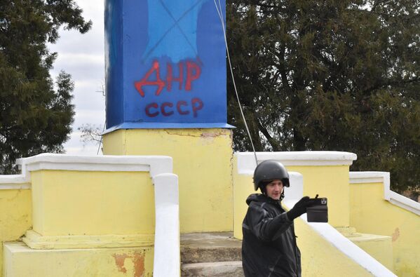 Журналист фотографируется на фоне монумента с надписью ДНР СССР в селе Гранитное - Sputnik Беларусь