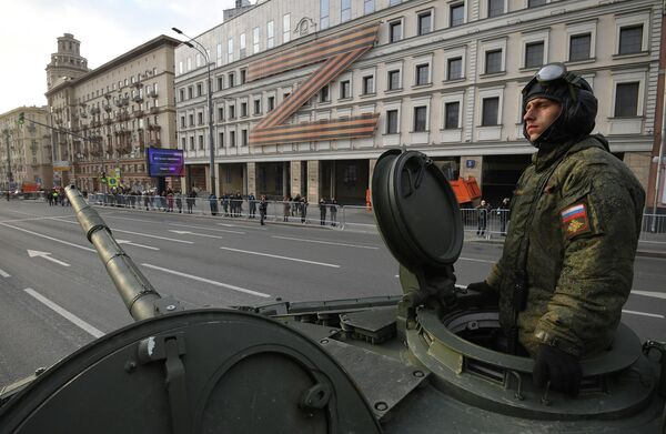 Военнослужащий в колонне военной техники двигается по улице в Москве к месту проведения ночной репетиции военного парада Победы в Москве - Sputnik Беларусь
