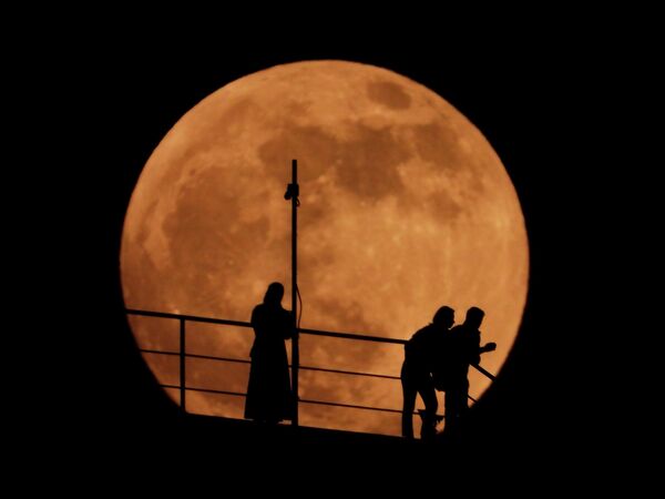Силуэты людей на фоне восходящей полной луны в Грозном, Россия. - Sputnik Беларусь