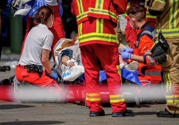 Спасатели помогают пострадавшему после того, как автомобиль врезался в толпу людей в центре Берлина - Sputnik Беларусь