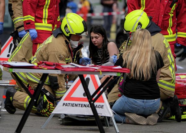 Спасатели помогают девушке на месте наезда автомобиля на людей в Берлине - Sputnik Беларусь