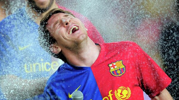 Нападающий Барселоны Жерар Пике обливает шампанским аргентинца Лионеля Месси после победы в чемпионате Испании против Осасуны в Барселоне - Sputnik Беларусь