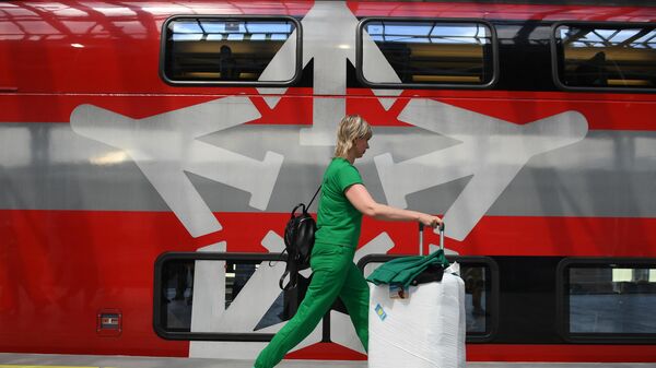 Девушка с чемоданом на перроне нового железнодорожного терминала для поездов Аэроэкспресс в аэропорту Шереметьево - Sputnik Беларусь