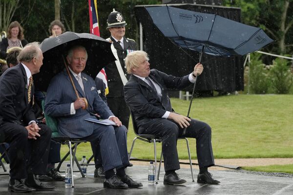 Британский принц Чарльз (в центре) и премьер-министр Борис Джонсон (справа) укрываются от дождя во время открытия Мемориала полиции Великобритании в Национальном мемориальном дендрарии в Алревасе, Англия, 28 июля 2021 года.Интерлюдия с зонтом обошла все соцсети. - Sputnik Беларусь
