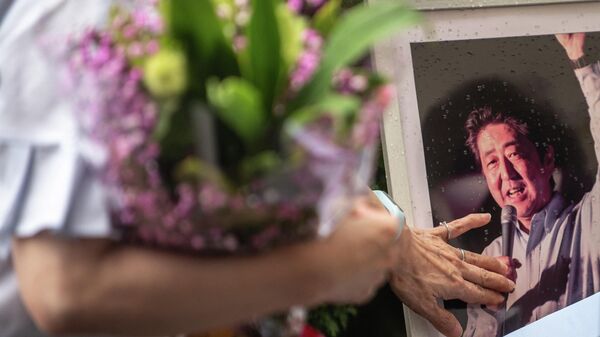 Люди несут цветы к месту убийства бывшего премьер-министра Японии Синдзо Абэ - Sputnik Беларусь
