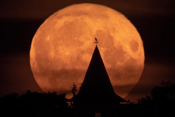 Полная луна над частным домом в деревне Путилово, в 70 км к востоку от Санкт-Петербурга. - Sputnik Беларусь