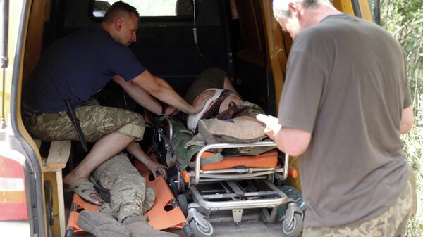 Украинские военнослужащие оказывают помощь раненому однополчанину - Sputnik Беларусь