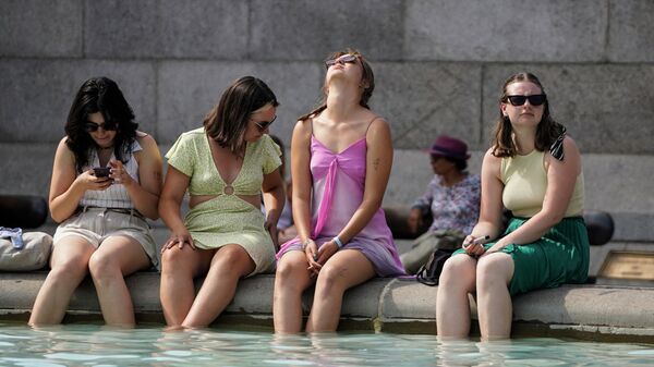 Девушки охлаждаются в фонтане на Трафальгарской площади во время жаркой погоды в Лондоне - Sputnik Беларусь