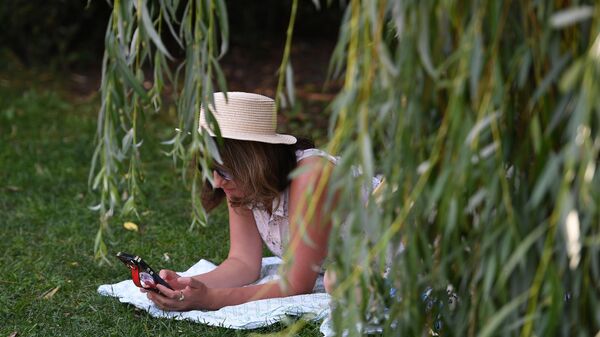 Девушка читает книгу в жаркую погоду в парке - Sputnik Беларусь