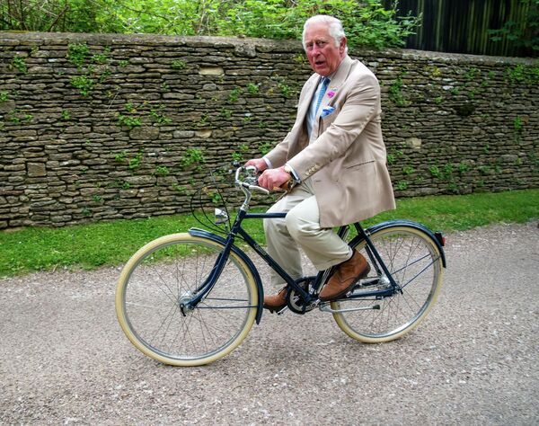 Британский принц Чарльз едет на велосипеде в Глостершире, 10 июня 2021 года.Несколько лет назад он поучаствовал в модной фотосессии Vogue, напомнив публике о своем безупречном стиле и особенном вкусе, и призвал публику к разумному потреблению и бережному отношению к одежде. - Sputnik Беларусь
