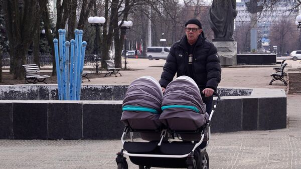 Мужчина с двойной прогулочной коляской в парке - Sputnik Беларусь