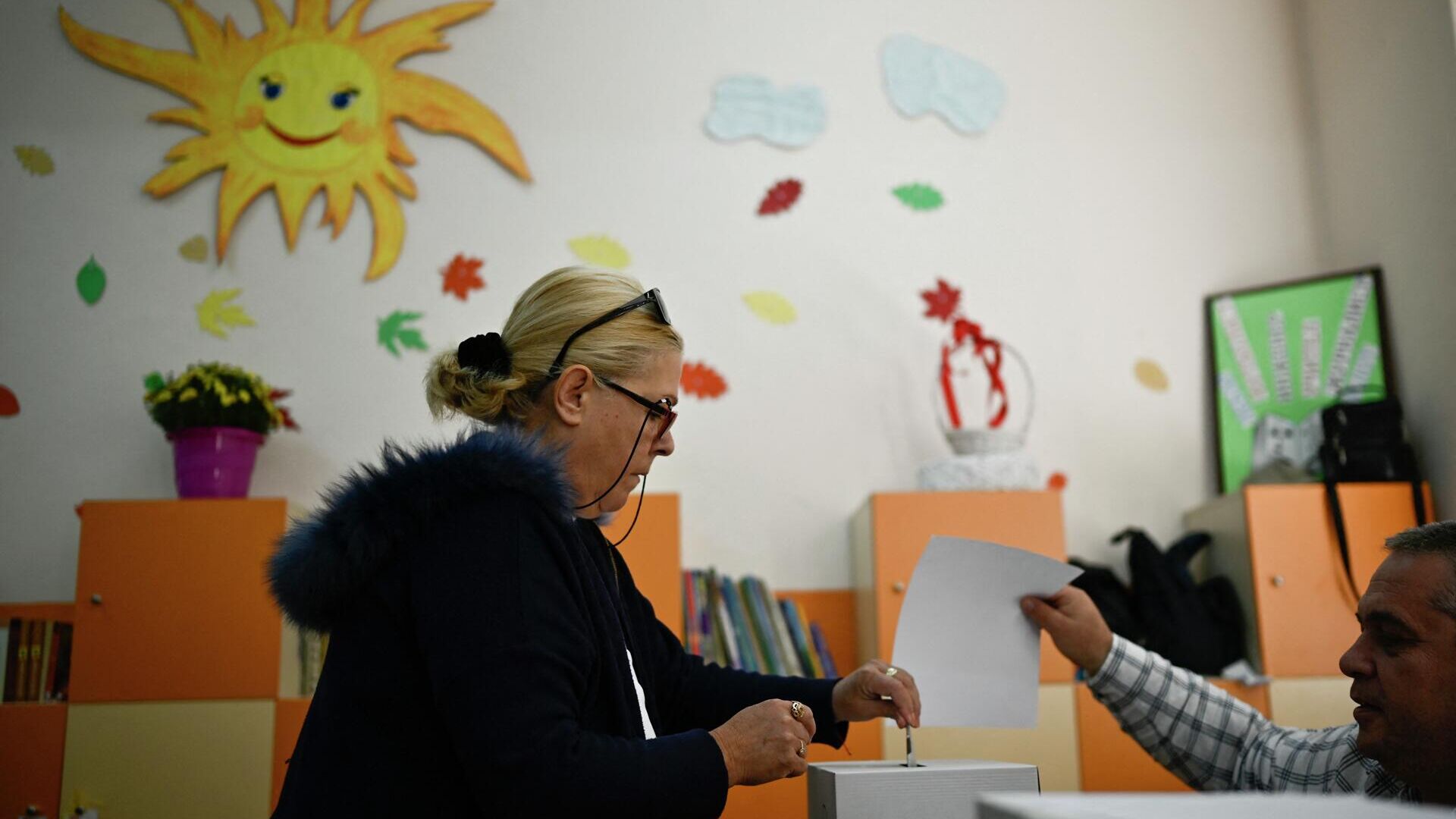 Женщина голосует на избирательном участке во время парламентских выборов в Софии 2 октября 2022 года - Sputnik Беларусь, 1920, 02.10.2022