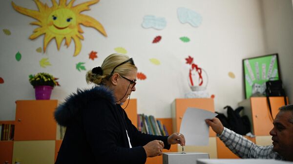 Женщина голосует на избирательном участке во время парламентских выборов в Софии 2 октября 2022 года - Sputnik Беларусь