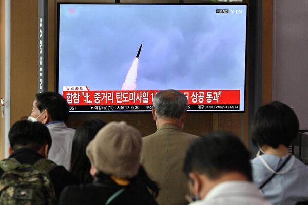 Люди следят за выпуском северокорейской ракеты на железнодорожной станции в Сеуле. - Sputnik Беларусь