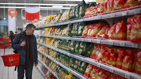 Мужчина выбирает макароны в гипермаркете - Sputnik Беларусь