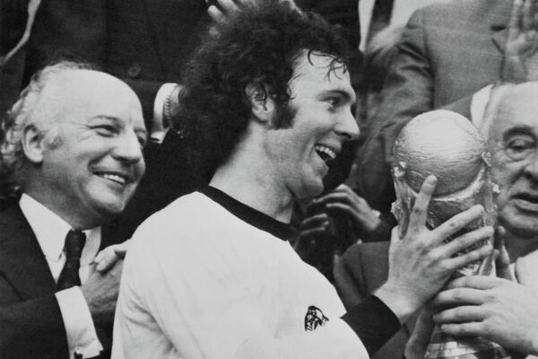 Капитан команды Франц Беккенбауэр держит трофей после победы своей команды в финале чемпионата мира по футболу &quot;Западная Германия — Голландия&quot; на Олимпийском стадионе в Мюнхене, 7 июля 1974 года. - Sputnik Беларусь