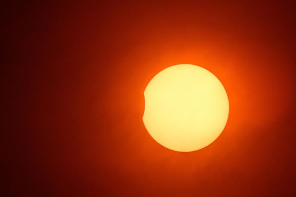 Частичное солнечное затмение в Эде-Базуж, западная Франция.Чтобы наблюдать за затмением, нужны специальные защитные средства: на Солнце ни в коем случае нельзя смотреть невооруженным глазом, тем более – в оптические приборы. - Sputnik Беларусь