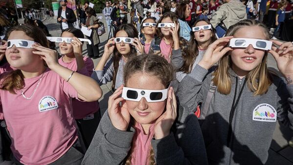 Студенты в солнцезащитных очках наблюдают за частичным солнечным затмением в столице Косово Приштине. - Sputnik Беларусь