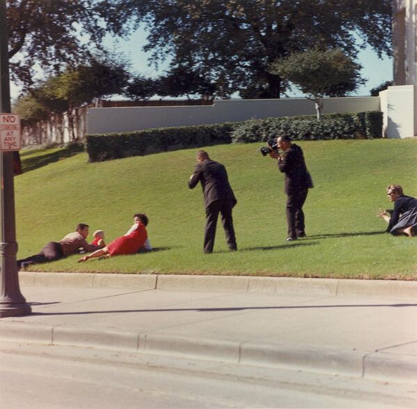 Билл и Джин Ньюман и их дети упали на землю через несколько секунд после убийства президента США Джона Ф. Кеннеди в Далласе, штат Техас, полагая, что они находятся на линии огня. Их фотографируют Том Крэйвен и Том Аткинс. На траве справа Шерил Маккиннон. - Sputnik Беларусь
