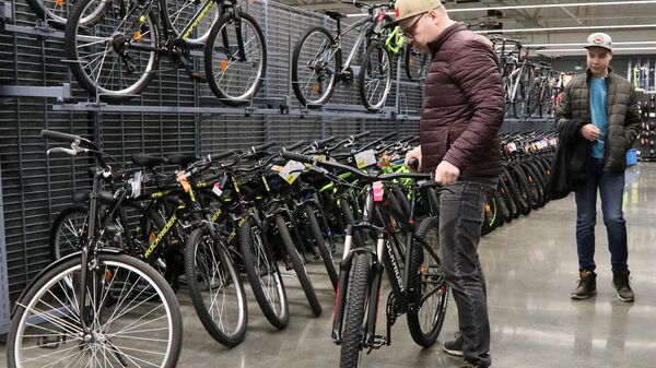 Мужчина выбирает велосипед в магазине  - Sputnik Беларусь
