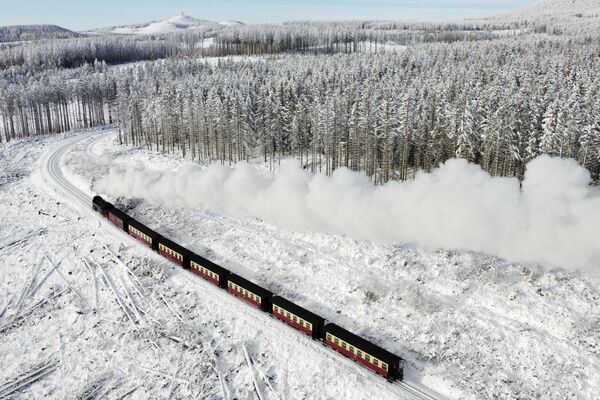 Паровоз проезжает по заснеженному ландшафту в горах Гарц близ Вернигероде, Германия - Sputnik Беларусь