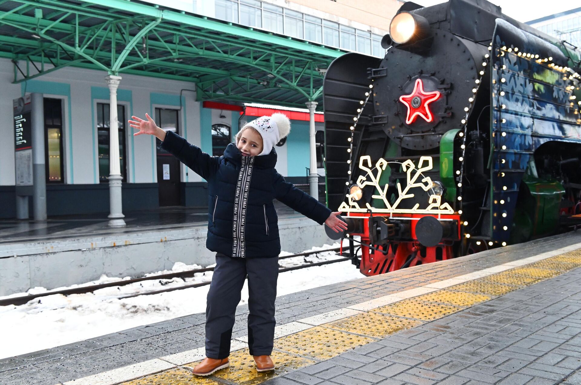 Девочка фотографируется на фоне поезда Деда Мороза на Белорусском вокзале в Москве - Sputnik Беларусь, 1920, 26.12.2022