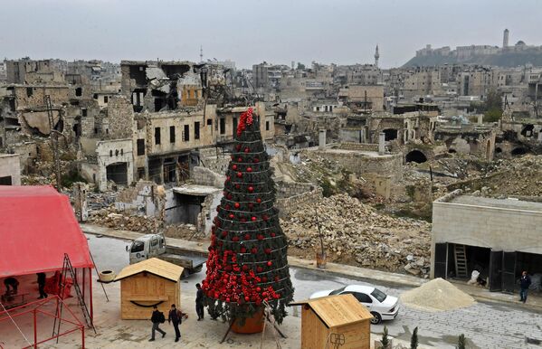 Рабочие устанавливают рождественскую елку на площади аль-Хатаб, одной из старейших в сирийском городе Алеппо. - Sputnik Беларусь