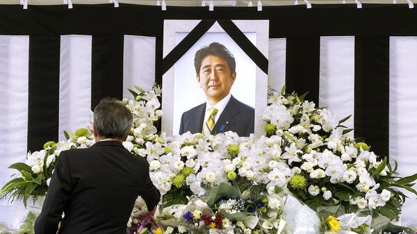 Мужчина у портрета Синдзо Абэ во время церемонии государственных похорон бывшего премьер-министра Японии Синдзо Абэ в Токио - Sputnik Беларусь
