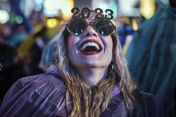 Девушка смеется, ожидая обратного отсчета до начала нового года на Таймс-сквер в Нью-Йорке 31 декабря 2022 года - Sputnik Беларусь