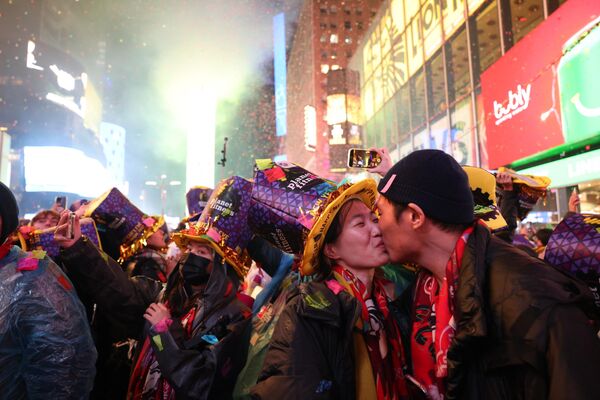 Люди целуются, когда начинает падать конфетти, чтобы отметить начало нового года, на Таймс-сквер, Нью-Йорк, 1 января 2023 года. - Sputnik Беларусь