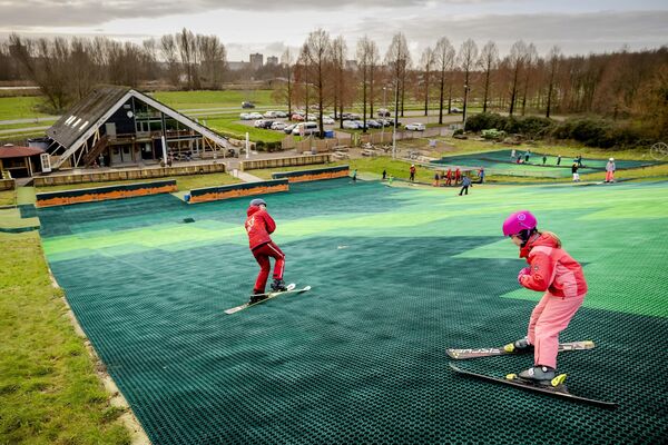 Дети посещают занятия по катанию на лыжах на искусственном горнолыжном склоне в Бергсенхуке, Нидерланды. - Sputnik Беларусь