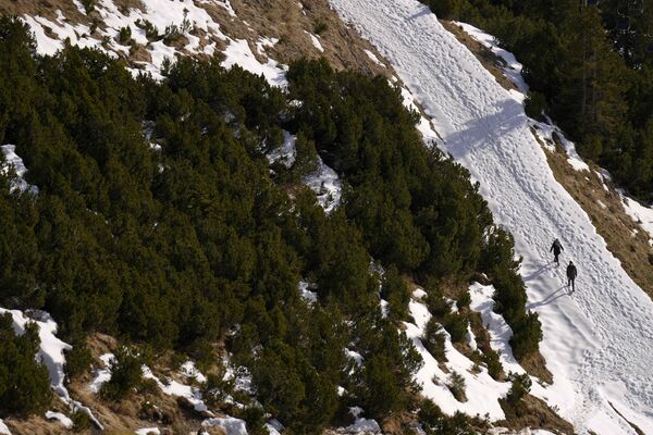 В высокогорных районах снег еще есть. На фото: люди пробираются по заснеженному ландшафту возле вершины Хафелекар высотой 2334 м в горах Нордкетте в Инсбруке, Австрия. - Sputnik Беларусь