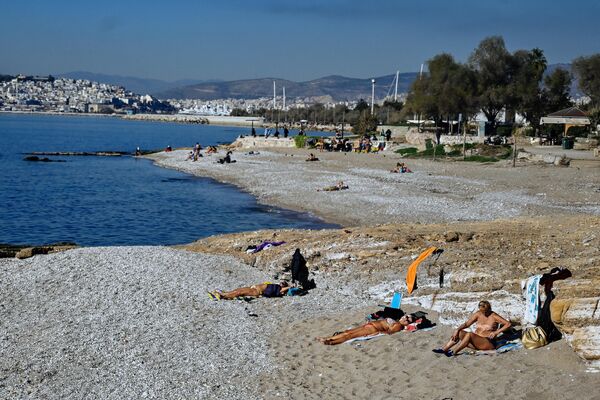 Еще теплее в Греции: жители загорают на пляже в Афинах 2 января 2023 года. - Sputnik Беларусь